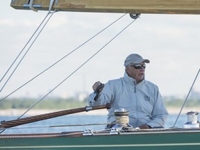 King Harald V of Norway sits in the driver's seat of his classic yacht as his majesty and his team compete for the Sira Cup on Lake Ontario in Toronto, Ontario on Monday, August 22, 2016.