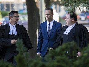 Sandro Lisi, joined by lawyers Seth Weinstein (left) and Domenic Basile, arrives at a Toronto courthouse on Thursday, where the extortion charge against him was dropped.