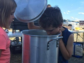 Blayke Coldwell and Brooke Nehring, both 6, disappointedly look into empty pots that were supposed to have fresh lobster cooking on Aug. 13 at a fundraiser in northern Alberta.
