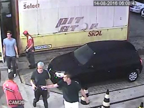 Swimmers from the U.S. Olympic team including Ryan Lochte, second from right, are seen in this image from surveillance video at a gas station in Rio de Janeiro from Sunday, Aug. 14.