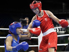 Canada's Mandy Bujold (right) knocks down China's Ren Cancan during a women's flyweight 51-kg quarterfinals boxing match at the 2016 Summer Olympics in Rio de Janeiro, Brazil, on Tuesday, Aug. 16, 2016.