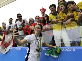 Canada's Diana Matheson, middle, takes a selfie with fans after winning the bronze medal in women's soccer at the Arena Corinthians stadium in Sao Paulo, Friday Aug. 19, 2016.