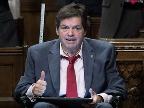 Mauril Belanger gives the thumbs up as he receives applause after using a tablet with text-to-speech program to defend his proposed changes to neutralize gender in the lyrics to "O Canada" in the House of Commons on Parliament Hill in Ottawa on Friday, May 6, 2016. The Ottawa-Vanier MP has died.