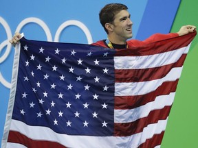 Michael Phelps walks with the American flag during the medal ceremony for the men's 4x100m medley relay final in Rio on Aug. 14.