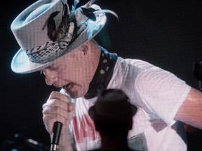 Lead singer Gord Downie is seen performing on a screen as a man watches during a viewing party for the final stop in Kingston, Ont., of a 10-city national concert tour by The Tragically Hip, in Vancouver, B.C., on Saturday.
