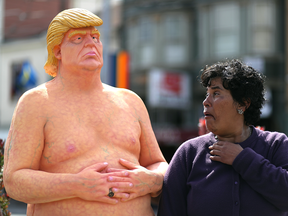 A passerby looks at a statue of Donald Trump in the nude in San Francisco