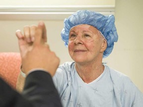 Noreen Smith of Bobcaygeon, Ont. tests out the steadiness of her hand with a neurosurgeon after undergoing an MRI-guided focused ultrasound for essential tremor, a common neurological condition that causes uncontrollable shaking, in a handout photo.