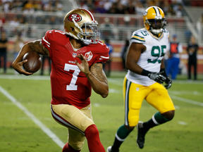 San Francisco 49ers quarterback Colin Kaepernick, left, runs with the ball during a preseason game against the Green Bay Packers on Aug. 26.