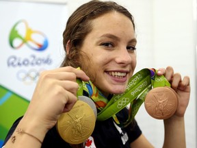 Four-time medallist Penny Oleksiak of Team Canada shows off her medals in Rio on Sunday.