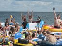 People celebrate as they start the Float Down at Lighthouse Beach in Port Huron, Mich., Sunday, Aug. 21, 2016. Thousands of people gathered for the event and floated down the St. Clair River. 