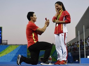 Silver medallist China's He Zi, receives a marriage proposal during the podium ceremony of the Women's diving 3m Springboard.
