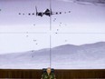 Lt.-Gen. Sergei Rudskoi of the Russian Military General Staff speaks to the media, as a video released by the Russian Defense Ministry shows a Russian warplane unloads its weapons over target on screen at a Russian Defense Ministry building in Moscow, Russia, Wednesday, Aug. 10, 2016.