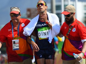 France's Yohann Diniz is helped by officials after competing in the men's 50km race walk