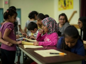 Syrian refugee children take part in a classroom activity while attending H.appi camp in Toronto on Tuesday July 12 , 2016.