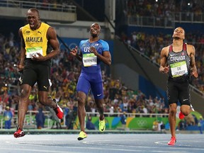 Andre de Grasse of Canada shows his dejection as Usain Bolt of Jamaica celebrates his gold medal in the 200m final at the 2016 Olympics on Thursday, Aug. 18, 2016.