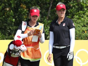 Brooke Henderson of Canada, right, consults with her caddie and sister Brittany on the tee at the 11th hole in the third round of women's golf on Friday, Aug. 19, 2016.