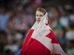 Draped in a Canadian flag, Derek Drouin celebrates his gold medal in men's high jump at Rio 2016 on Aug. 16.