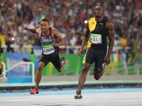 In this Aug. 14, 2016 file photo, Andre De Grasse (left) and Usain Bolt cross the finish line in the 100 metres at the Rio Olympics.