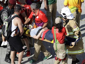 A woman is taken away on a backboard after being struck by overhead camera that fell from the wires that suspended it over Olympic Park, Monday, Aug. 15, 2016, at the 2016 Summer Olympics in Rio de Janeiro, Brazil.