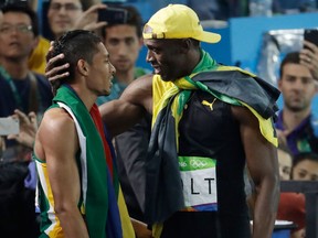 Jamaica's Usain Bolt, right, winner of the men's 100-meter final embraces South Africa's Wayde Van Niekerk, winner of the men's 400-meter final.