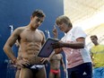 Britain's Tom Daley watches a video replay of his dive with coach Jane Figueirdo during a training session in the Maria Lenk Aquatic Center at the 2016 Summer Olympics in Rio de Janeiro, Brazil on Aug. 6, 2016.