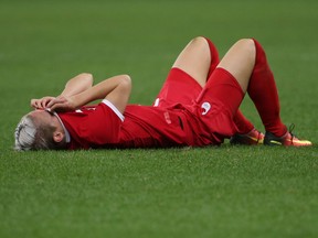 Canada's Sophie Schmidt lies on the field reacting at the end of the semi-final match of Olympic football.
