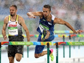 Matthias Buhler of Germany and Milan Trajkovic of Cyprus compete in the rain during the Men's 110m Hurdles Round 1 - Heat 2
