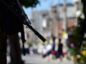 Army soldiers patrol the entrance of the Vila do Joao shantytown where a soldier was shot dead by drug gangs after entering by mistake.