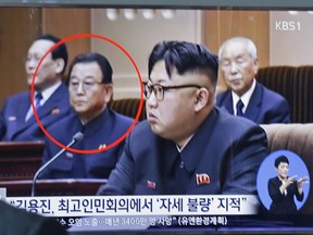 A TV screen shows Kim Yong Jin, second from left, a vice premier on education affairs in North Korea's cabinet, and North Korean leader Kim Jong Un, second from right.