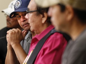 Leon Swanson, left, at a press conference in Winnipeg, Friday, August 26, 2016 where Manitoba's former aboriginal affairs minister Eric Robinson, centre, announced Swanson and David Tait Jr., right, were switched at birth in 1975.