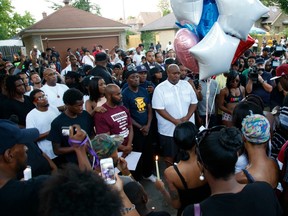 Family members of Sylville Smith and others gather where he was shot and killed by Milwaukee police in Milwaukee, Sunday, Aug. 14, 2016.