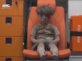 In this frame grab taken from video provided by the Syrian anti-government activist group, Omran Daqneesh, 5, sits in an ambulance after being pulled out or a building hit by an airstirke, in Aleppo, Syria,  on August 17, 2016.