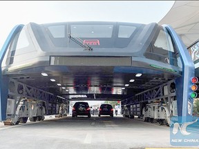 Cars run under the transit elevated bus during its road test in Qinhuangdao