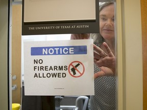 University of Texas at Austin Anthropology professor Pauline Strong posts a sign prohibiting guns at her office on the first day of the new campus-carry law Monday, Aug. 1, 2016