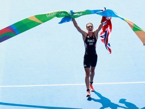 Alistair Brownlee of Great Britain celebrates after crossing the finish line to win the gold medal in the men's triathlon at Fort Copacabana on Thursday, Aug. 18, 2016.