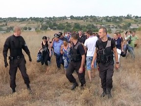 Ukrainian police officers escort Roma residents from the village of Loshchynivka, Odessa region, Ukraine, on August 28.