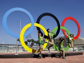 Volunteers pose for a photograph someone took for them by the Olympics Rings in the Olympic Park ahead of the start of the 2016 Summer Olympics in Rio de Janeiro, Brazil, Monday, Aug. 1, 2016.