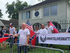 In this Sunday, Aug. 21, 2016, photo, people with a White Lives Matter sign demonstrate in front of the NAACP office in Houston, Texas.