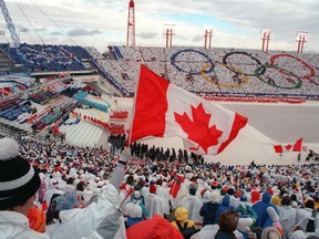 Fans wave flags during the opening ceremony of the Calgary Olympics on Feb. 13, 1988.
