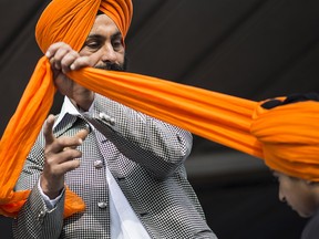 A Sikh man ties a turban during the 2013 Khalsa Vaisakhi Parade in Surrey, British Columbia. The Quebec Superior Court has ruled against an application to have hard hats exempted for turban-wearing Sikhs working at the Port of Montreal.