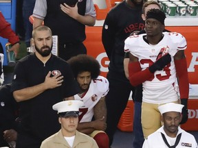 San Francisco 49ers quarterback Colin Kaepernick, middle, kneels during the national anthem before the team's NFL preseason football game against the San Diego Chargers, Thursday, Sept. 1, 2016, in San Diego.