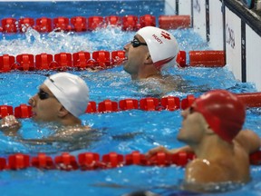 Benoit Huot (centre) reacts after competing in the men's 100-metre backstroke - S10 in Rio on Sept. 10.