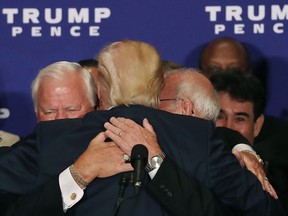 Donald Trump (C), hugs Medal of Honour recipient during a campaign event at the Trump International Hotel, September 16, 2016 in Washington, DC.