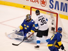 Swedish goaltender Henrik Lundqvist (left) makes one of his 36 saves in Sweden's 2-0 win over Finland on Sept. 20.