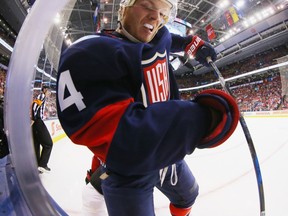 U.S. defenceman John Carlson hits the boards in his team's 4-2 loss to Canada on Sept. 20.
