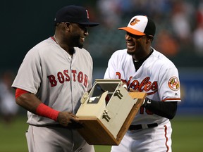 Adam Jones #10 of the Baltimore Orioles presents David Ortiz #34 of the Boston Red Sox with the dugout telephone Ortiz broke on July 27, 2013 during his retirement ceremony at Oriole Park at Camden Yards on September 22, 2016 in Baltimore, Maryland.