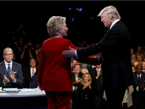 Democratic presidential nominee Hillary Clinton shakes hands with Republican presidential nominee Donald Trump as Moderator Lester Holt looks on during the Presidential Debate at Hofstra University on September 26, 2016 in Hempstead, New York.