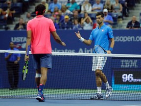 Jo-Wilfried Tsonga of France, left, greets Novak Djokovic of Serbia at the net after Tzonga was forced to retire due to injury in their U.S. Open men's quarter-final match in New York on Tuesday. Djokovic reached his 10th straight semifinal at the U.S. Open when Tsonga retired from their match with a left knee injury while trailing 6-3, 6-2.