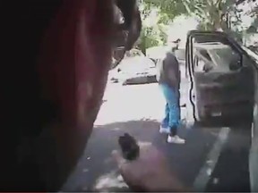 A still from police body camera footage shows Keith Lamont Scott (R) looking on as a police officer aproaches in Charlotte, North Carolina on September 20, 2016.