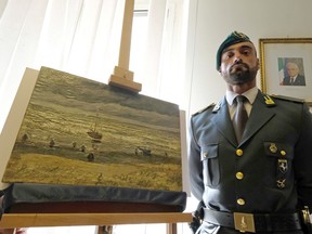 An Italian Border policeman stands next to "The Beach At Scheveningen During A Storm", one of the two Van Gogh paintings stolen in Amsterdam 14 years ago and recently recovered.